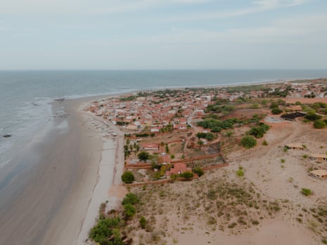 An aerial view of a town seemingly built on sand dunes by a beach