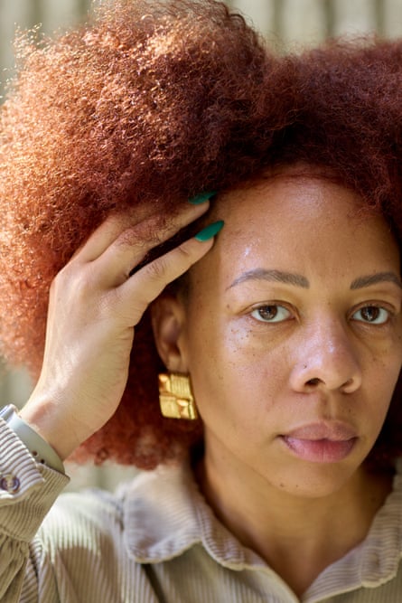 Woman with afro holds side of her head