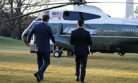 White House staff members carry boxes to Marine One before President Donald Trump leaves the White House on 20 January 2021.