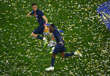 Paris Saint-Germain’s Achraf Hakimi and Ousmane Dembélé celebrate with the Champions League trophy