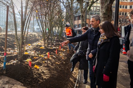 A man points out newly planted trees to Anne Hidalgo