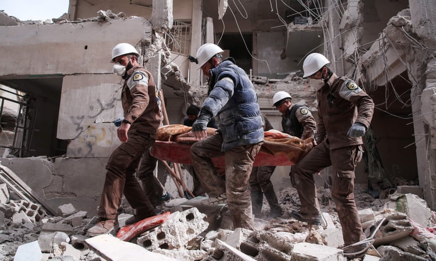 Members of the White Helmets search for survivors following an airstrike on a rebel-held neighbourhood on the outskirts of Damascus in 2016.