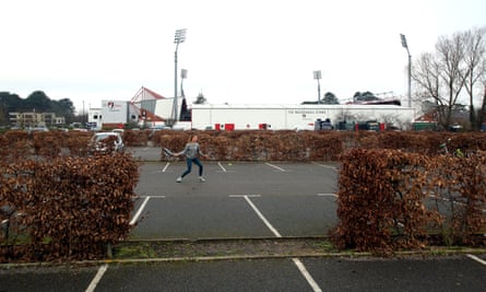 A woman plays tennis in an empty car park at the Vitality Stadium.