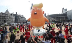 US Marine helicopters pass the 'Baby Trump' balloon as it rises after being inflated  in London's Parliament Square