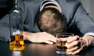 alcohol addiction - drunk businessman holding a glass of whiskey on the table