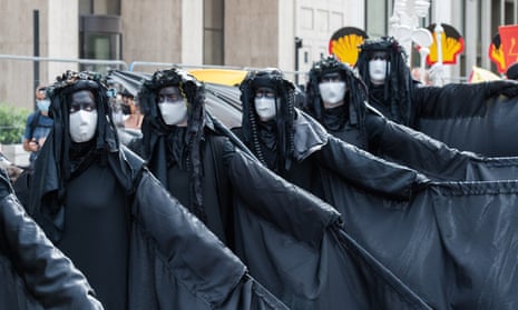 Extinction Rebellion activists wearing lack protesting against Shell