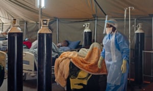 A medical worker wearing a protective suit treats coronavirus patients at an isolation ward in a hospital in Pretoria, South Africa, 10 July 2020.