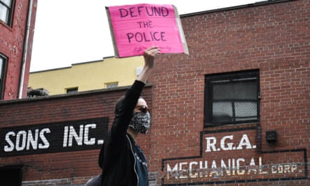 A woman holds a placard reading ‘Defund the Police’ during a demonstration in Manhattan over the death of George Floyd.