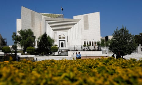 Police officers walk past the building housing Pakistan’s supreme court in Islamabad.