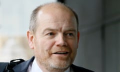 Balding middle-aged white man with stubble in a suit and tie.