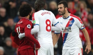 Luka Milivojevic confronts Mohamed Salah of Liverpool after his fall.