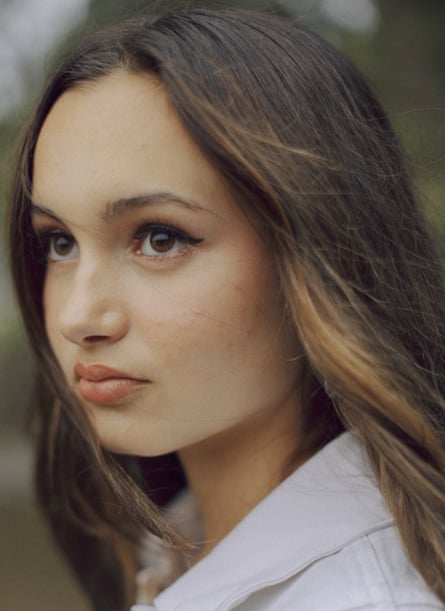 A young woman looks to the side.
