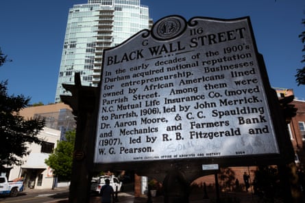 A historical marker dedicated to Durham’s ‘Black Wall Street’ can be seen downtown near a high-rise that consists of luxury apartments and condos.