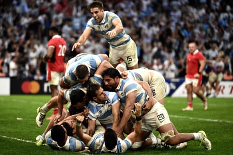 Argentina's players mob Nicolás Sánchez after he dived in to score their decisive late try.