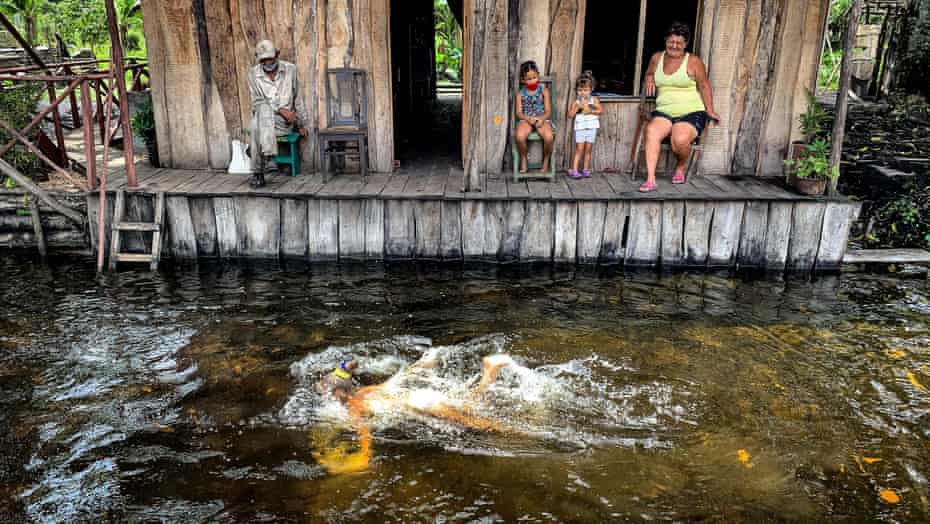 A woman swims near a family of charcoal producers