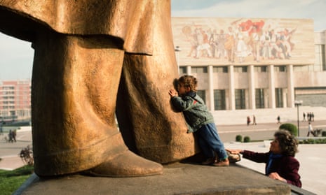 boy kissing the feet of the statue of Enver Hoxha in Tirana, 199o.