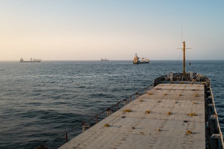 Photo taken from one of the vessels with view looking out at three other vessels anchored nearby.