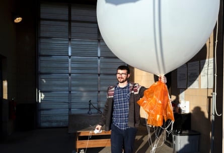 a man holds a large white balloon