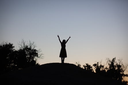 Silhouette of a woman atop a hill