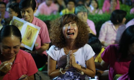 Thai women cry as they hear the news of the death of Thai king Bhumibol Adulyadej outside Siriraj hospital in Bangkok