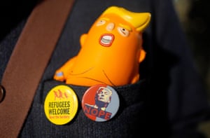 buttons read ‘refugees welcome’ and ‘nope’, while a cartoon depiction of an orange Trump rests in a pocket
