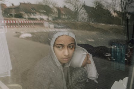 Lubna looking out of a train or coach window.