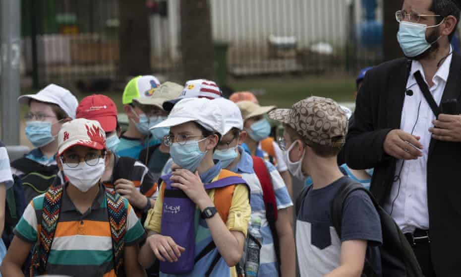 Israeli school children wear face masks to help prevent the spread of the coronavirus as they walk in Tel Aviv last week.