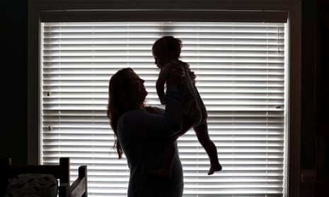 a silhouette of a woman holding up a baby in front of a window
