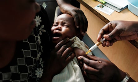 A mother holds her baby as she receives a malaria vaccine in Kombewa, Kenya.
