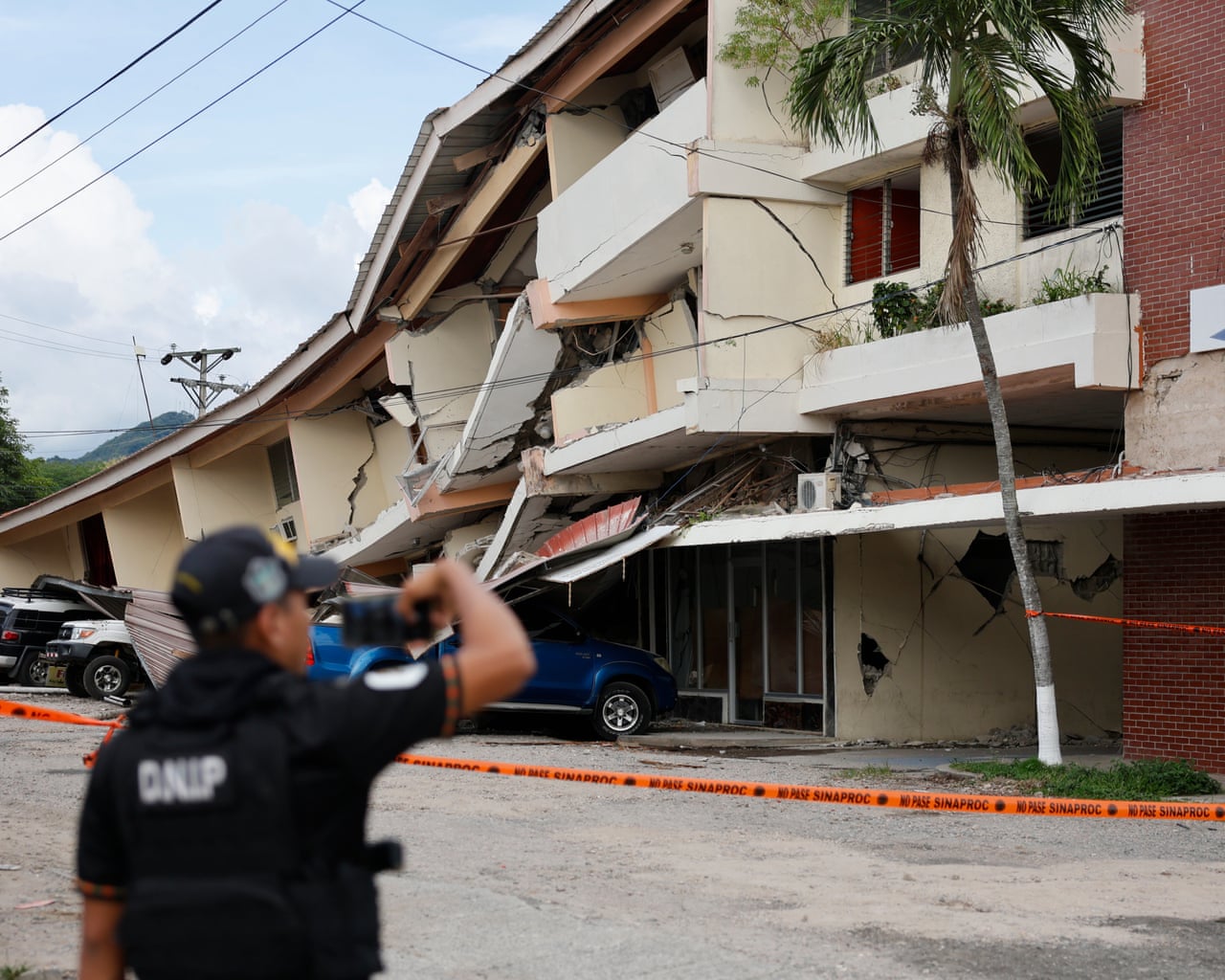 A person looks at buildings damaged by the earthquake