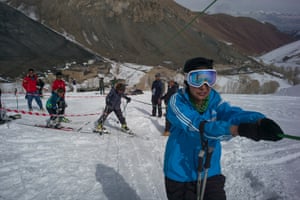Nazira holds the tow-rope as she is taken up the ski hill during a day of practice.