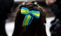 The back of a girl's head with a blue and yellow hair bow