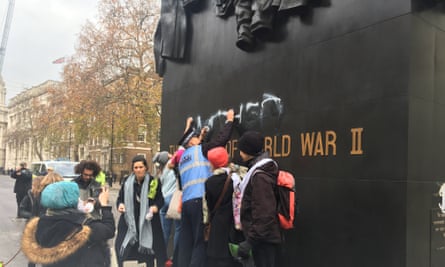 Police and protesters remove graffiti from the memorial to the women of the second world war in Whitehall.