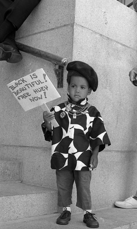 A young demonstrator in black beret holds a sign saying: ‘Black is beautiful! Free Huey Now!’