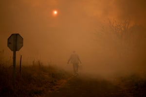 A figure carries a bucket in a red mist