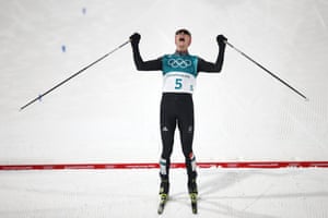 Germany’s Eric Frenzel celebrates as he crosses the line to win gold in the Nordic combined men’s individual normal hill / 10km cross country.