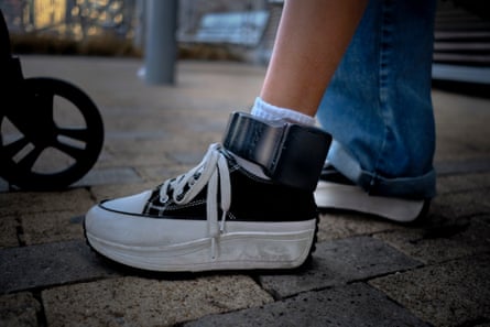A woman’s ankle with an electronic device strapped to it.