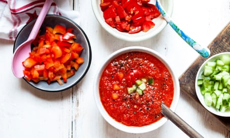 A bowl of gazpacho with cucumber and red pepper topping