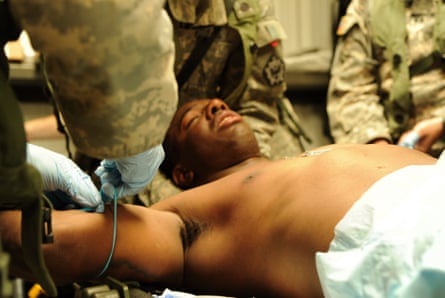army medics treat a man lying down
