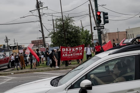 A car passes by in front of pro-choice protesters