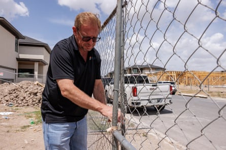 a man at a construction site locks a gate