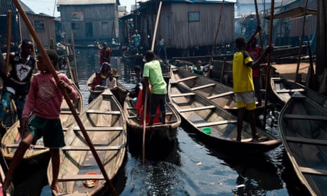 People row boats in a makeshift home in the Makoko riverine slum settlement in Lagos, Nigeria