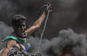 A Palestinian protester holds rope during clashes near the border with Israel in the east of the Gaza Strip