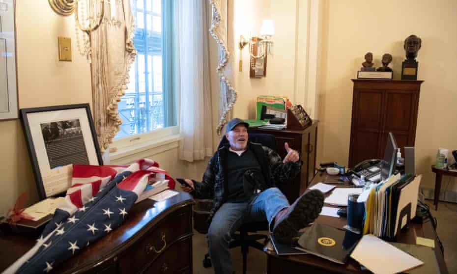 A Trump supporter identified as Richard Barnett sits inside the House speaker’s office on Wednesday.