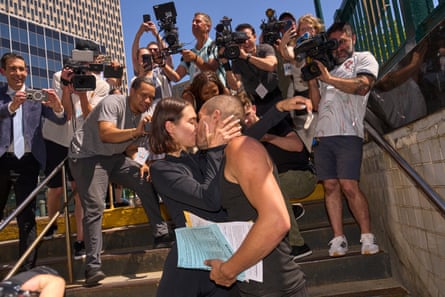 a couple kisses on a staircase as people film them