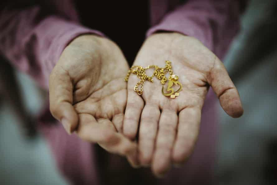 A Yazidi woman who decided to reunite with her daughter in defiance of her community shows a necklace she bought the previous day as a gift for her