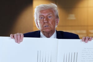 Donald Trump shows the pages of a guest book to the camera