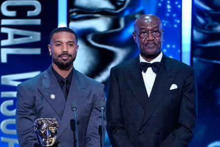 two men stand on stage