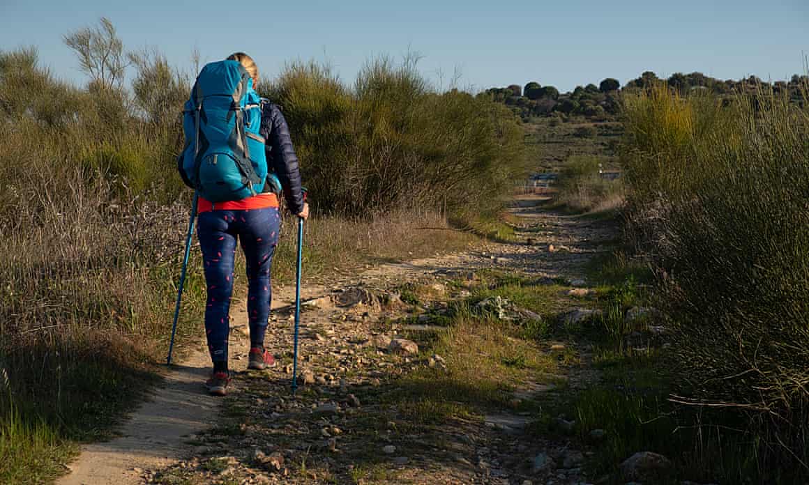 A woman pictured from behind walking the trail
