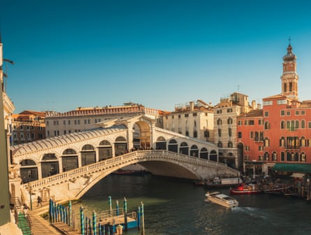 Ornate old bridge in Venice over canal in morning light